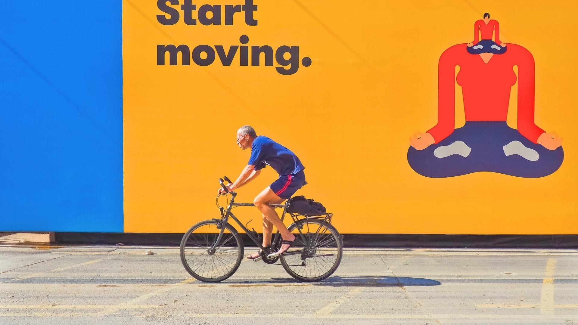 print advertising in michigan man riding bicycle by yellow and blue wall advertisment